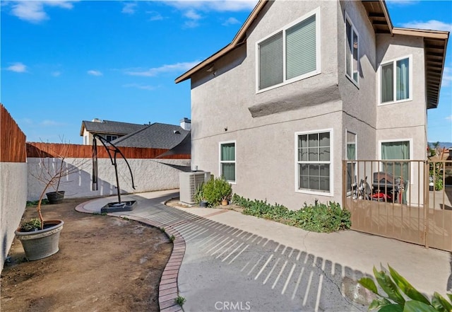 back of property with cooling unit and a patio area