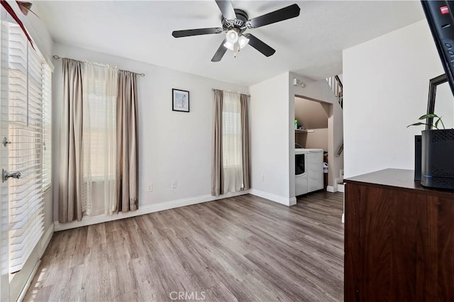 unfurnished living room featuring ceiling fan, washer / clothes dryer, and light hardwood / wood-style flooring