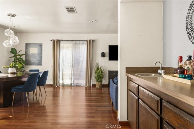 interior space featuring sink, hanging light fixtures, and dark hardwood / wood-style floors