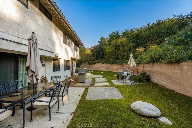 view of yard with a fenced backyard, outdoor dining area, and a patio