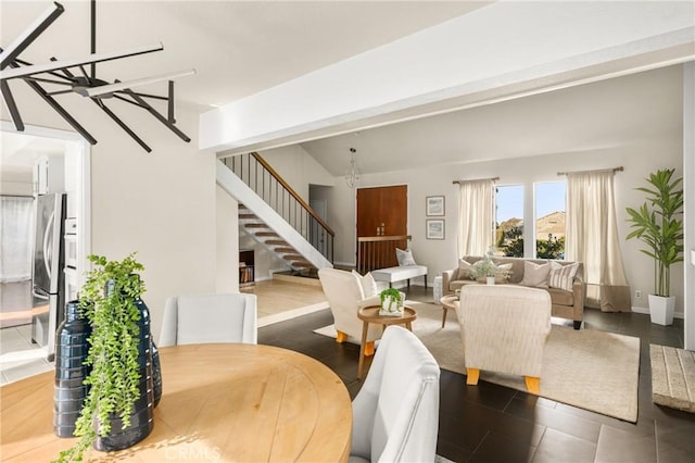 living room featuring a chandelier, stairway, and baseboards