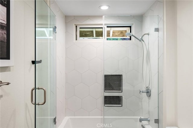 bathroom with a wealth of natural light and a shower with shower door