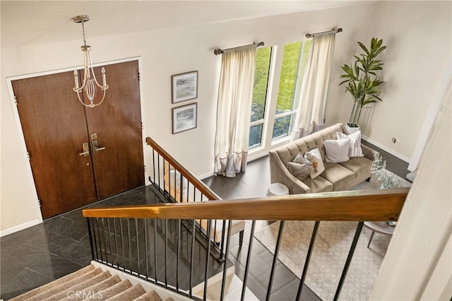 foyer entrance with stairs and baseboards
