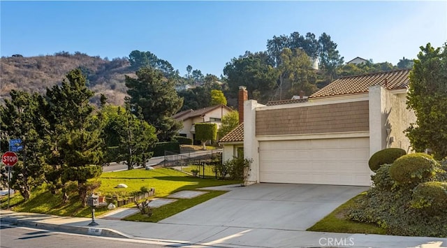 view of front of property with a mountain view, a garage, and a front yard