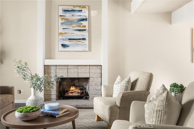 living room featuring baseboards and a tile fireplace