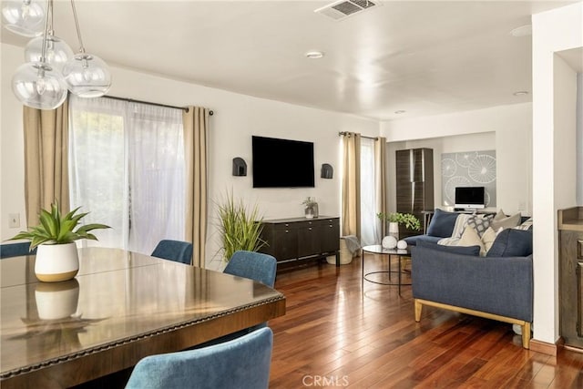 living room with plenty of natural light and dark hardwood / wood-style flooring