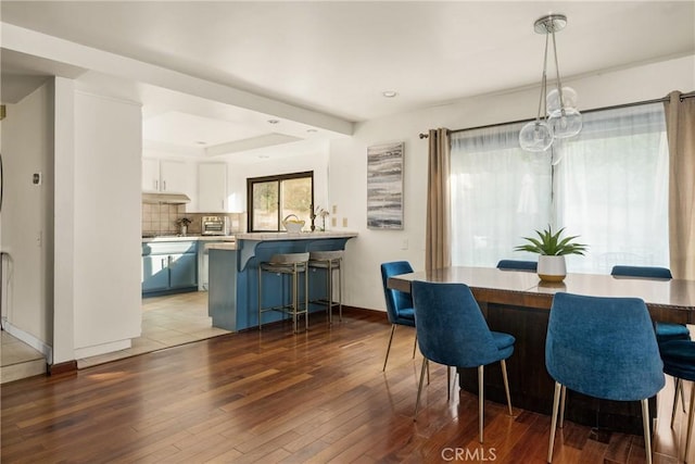 dining area featuring a raised ceiling and hardwood / wood-style floors