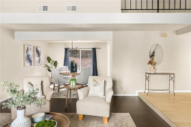 living area featuring a chandelier, visible vents, and baseboards