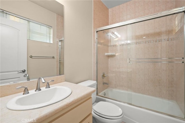 full bathroom featuring shower / bath combination with glass door, vanity, and toilet