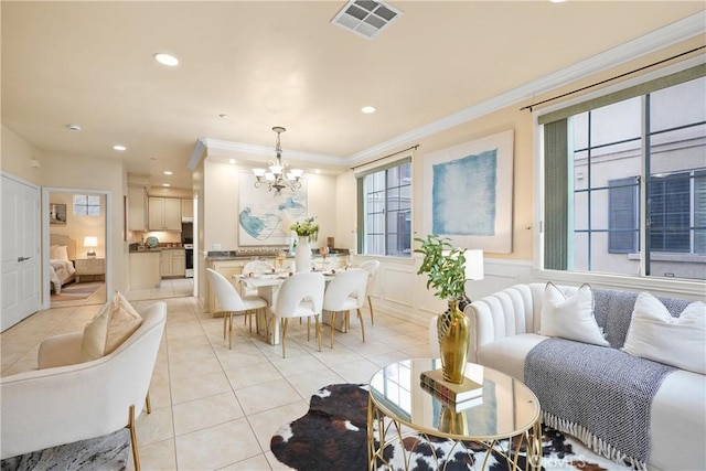 tiled living room with a healthy amount of sunlight, an inviting chandelier, and ornamental molding