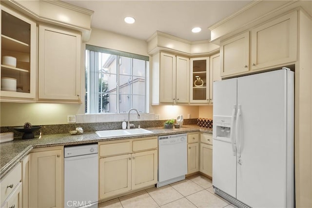 kitchen featuring cream cabinets, white appliances, light tile patterned floors, and sink