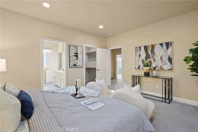 bedroom featuring ensuite bath and light colored carpet