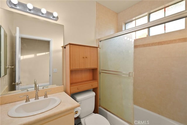 full bathroom featuring vanity, toilet, and combined bath / shower with glass door