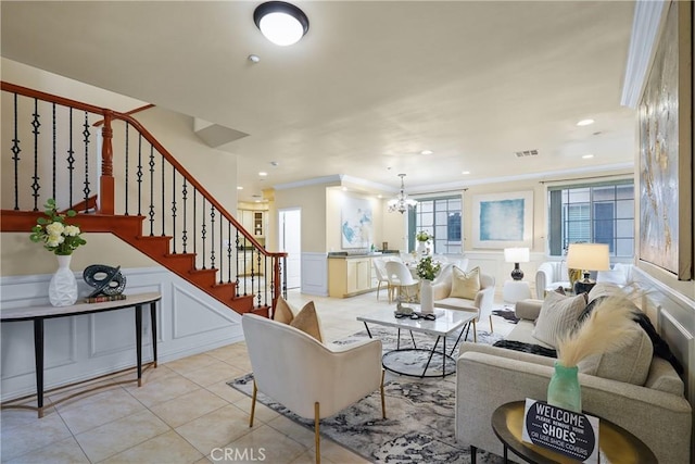 living room with crown molding, light tile patterned floors, and an inviting chandelier