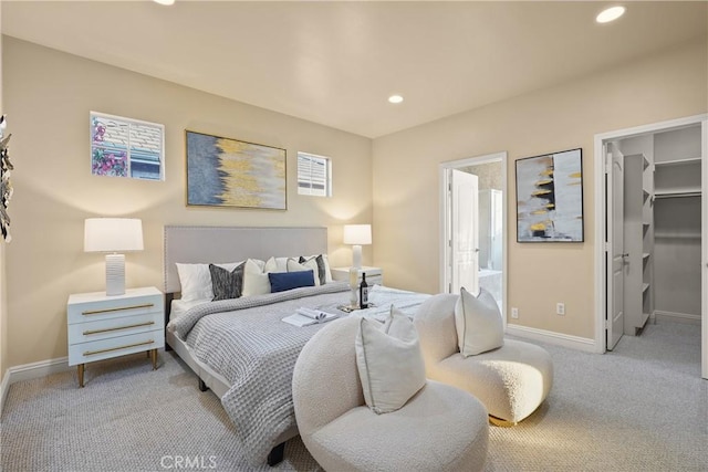 carpeted bedroom featuring a walk in closet and ensuite bath