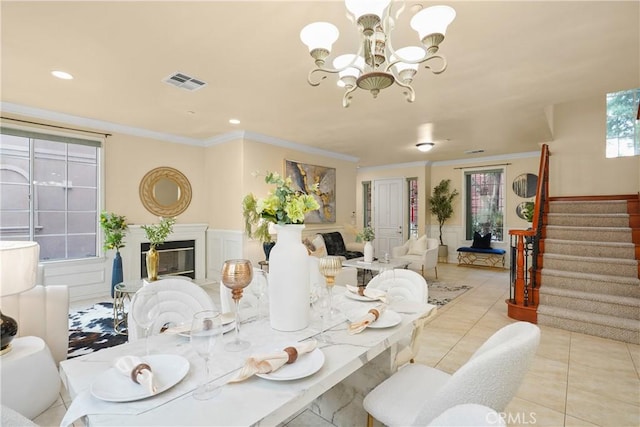 tiled dining space with ornamental molding and an inviting chandelier