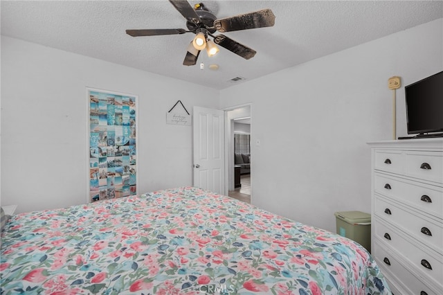 bedroom featuring ceiling fan and a textured ceiling