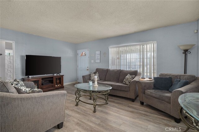 living room with light hardwood / wood-style flooring and a textured ceiling