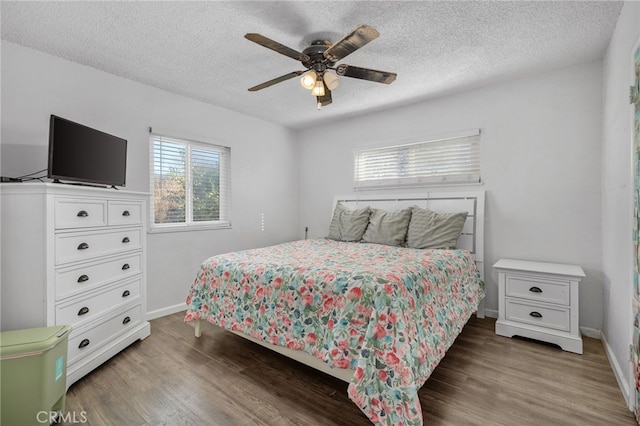 bedroom with a textured ceiling, ceiling fan, and dark hardwood / wood-style floors