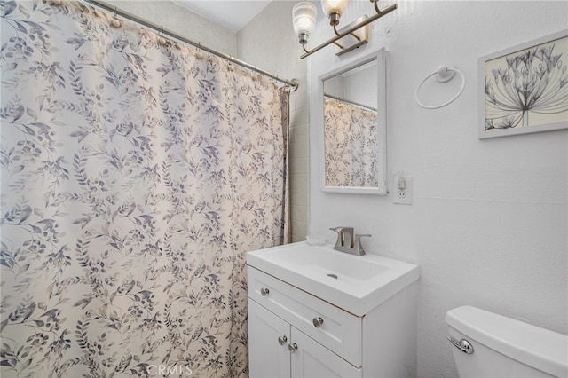 bathroom featuring a shower with curtain, vanity, and toilet