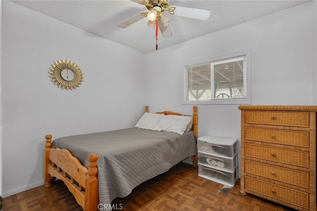 bedroom with ceiling fan and dark parquet floors