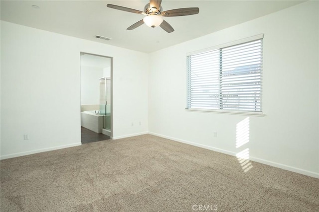 spare room with ceiling fan and carpet