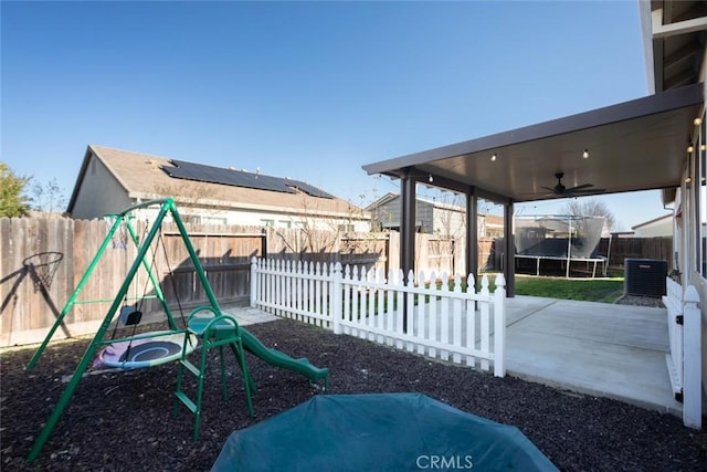 exterior space with a playground, ceiling fan, a trampoline, and central AC