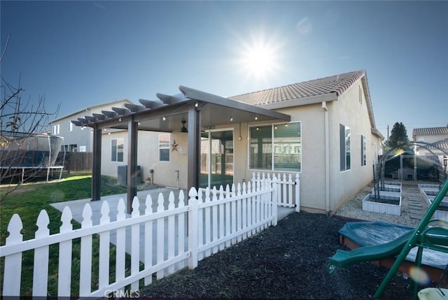 rear view of property with a trampoline