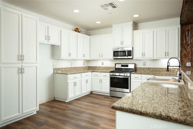 kitchen featuring sink, white cabinets, appliances with stainless steel finishes, and dark stone countertops