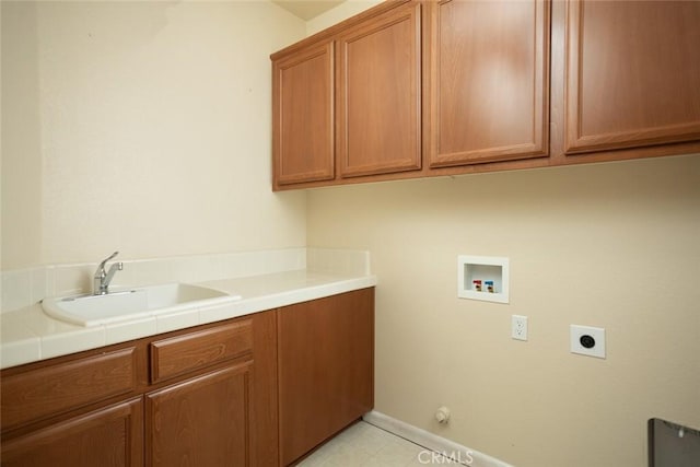 clothes washing area with cabinets, hookup for a gas dryer, electric dryer hookup, sink, and hookup for a washing machine