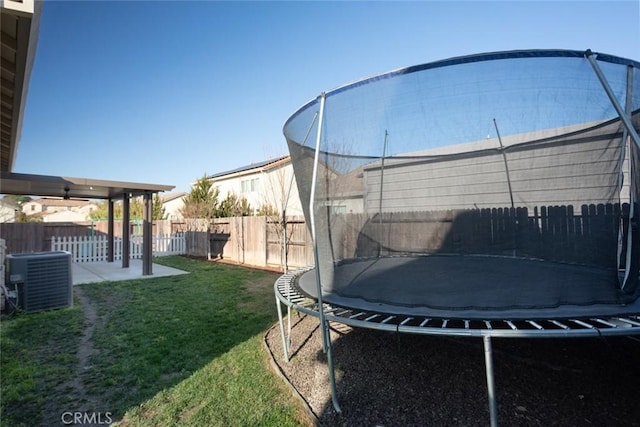 view of yard featuring central air condition unit, a trampoline, and a patio