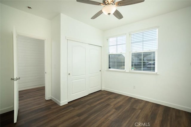 unfurnished bedroom featuring ceiling fan, dark hardwood / wood-style floors, and a closet