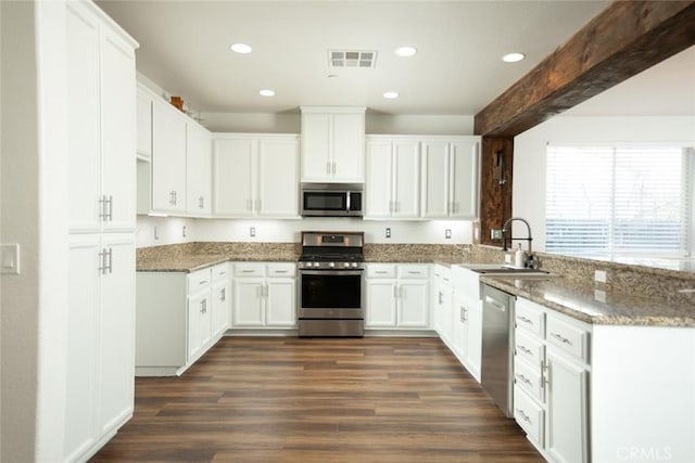 kitchen with white cabinetry, stainless steel appliances, sink, dark hardwood / wood-style floors, and stone counters