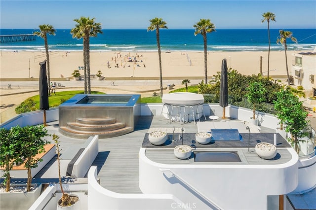 view of patio with a water view and a view of the beach