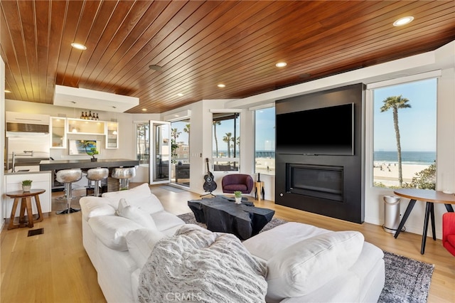 living room with light hardwood / wood-style flooring, an AC wall unit, and wood ceiling