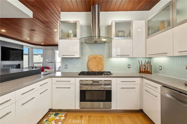 kitchen with wooden ceiling, wall chimney range hood, white cabinets, and appliances with stainless steel finishes