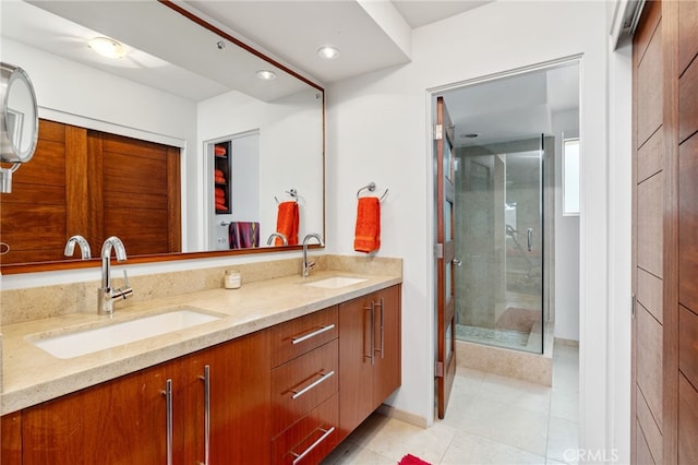 full bath with tile patterned flooring, a shower stall, double vanity, and a sink