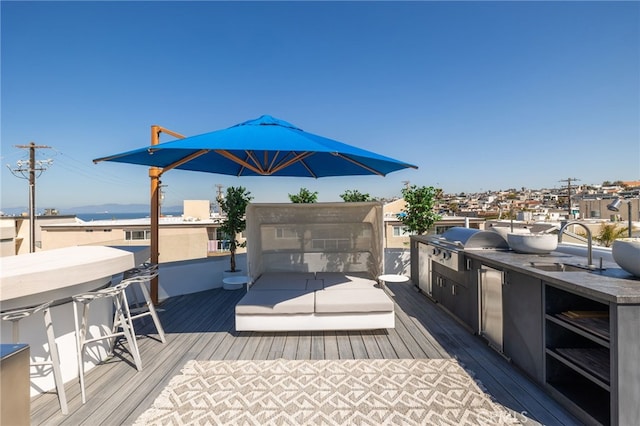 wooden terrace with a sink, exterior kitchen, and a grill