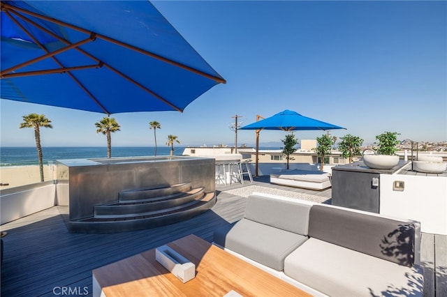 wooden deck featuring an outdoor living space, a jacuzzi, and a water view