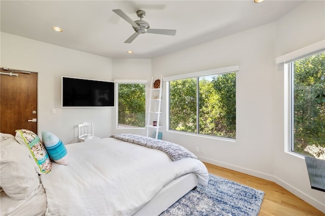 bedroom with recessed lighting, baseboards, multiple windows, and light wood-style floors