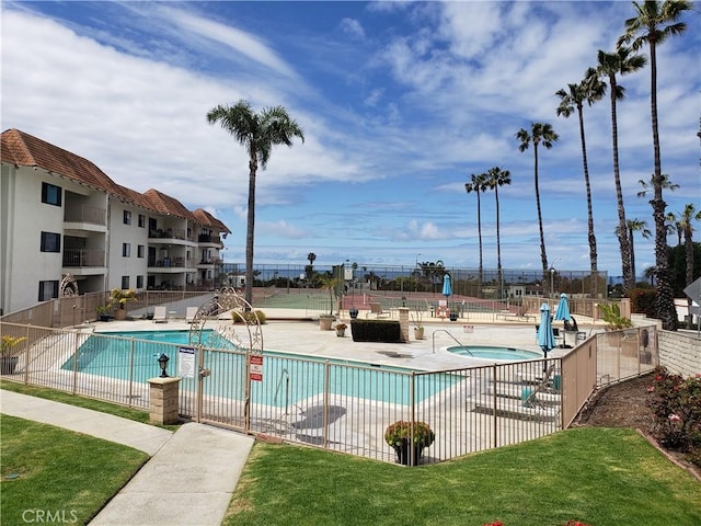 view of pool featuring a yard, a patio, and a hot tub