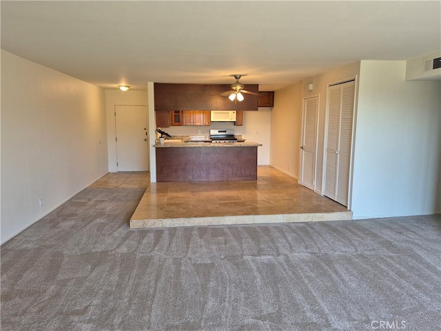 kitchen with ceiling fan, stainless steel range oven, kitchen peninsula, and light carpet