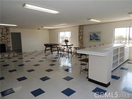 kitchen with plenty of natural light, a center island, a stone fireplace, and a breakfast bar