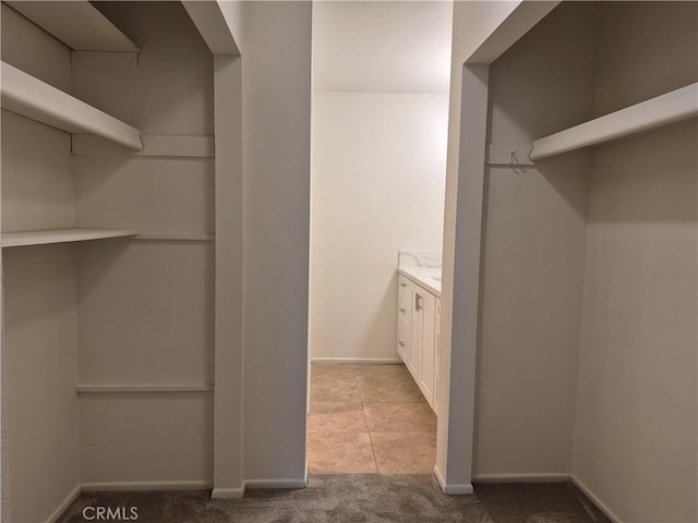 walk in closet featuring light colored carpet