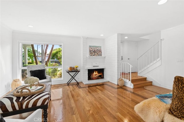 sitting room with crown molding, wood-type flooring, and a fireplace