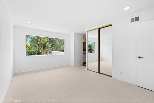 spare room featuring light carpet and ornamental molding