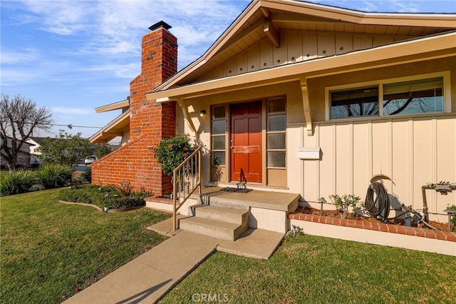 view of exterior entry with a yard