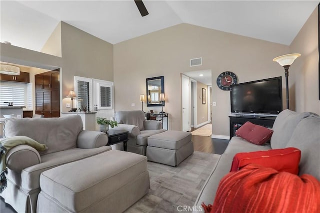 living room featuring ceiling fan, light hardwood / wood-style flooring, and lofted ceiling