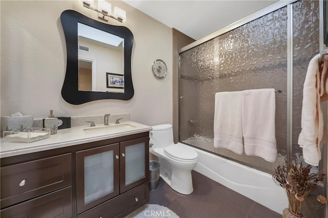 full bathroom with toilet, shower / bath combination with glass door, and vanity