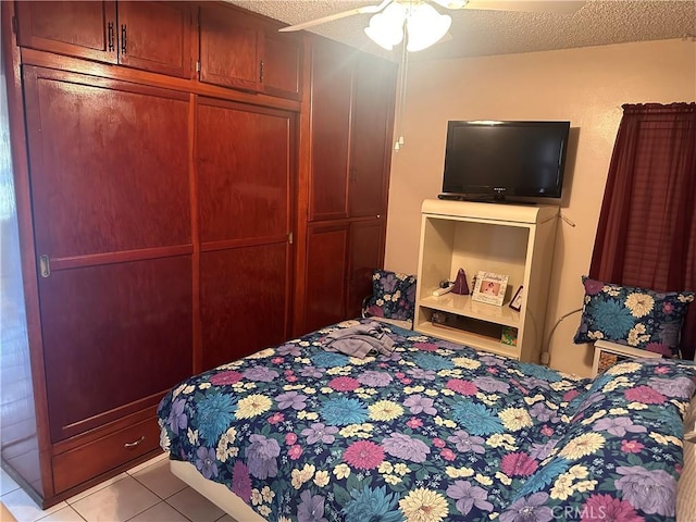 tiled bedroom featuring ceiling fan and a textured ceiling